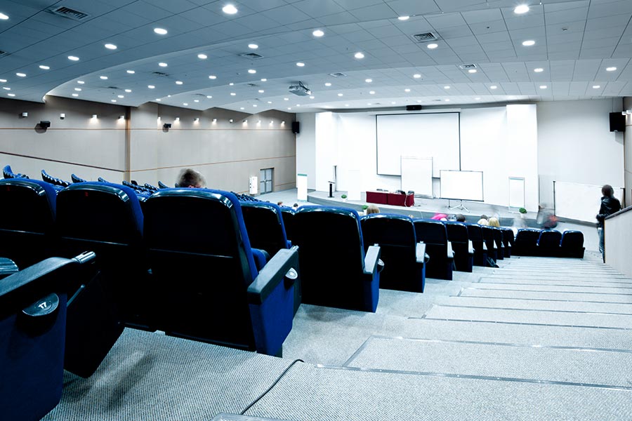 The picture shows a large empty lecture hall.